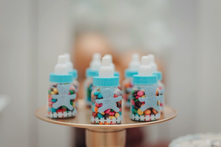 Vibrant candies in baby bottles on a tray, perfect for a baby shower or kids' party.